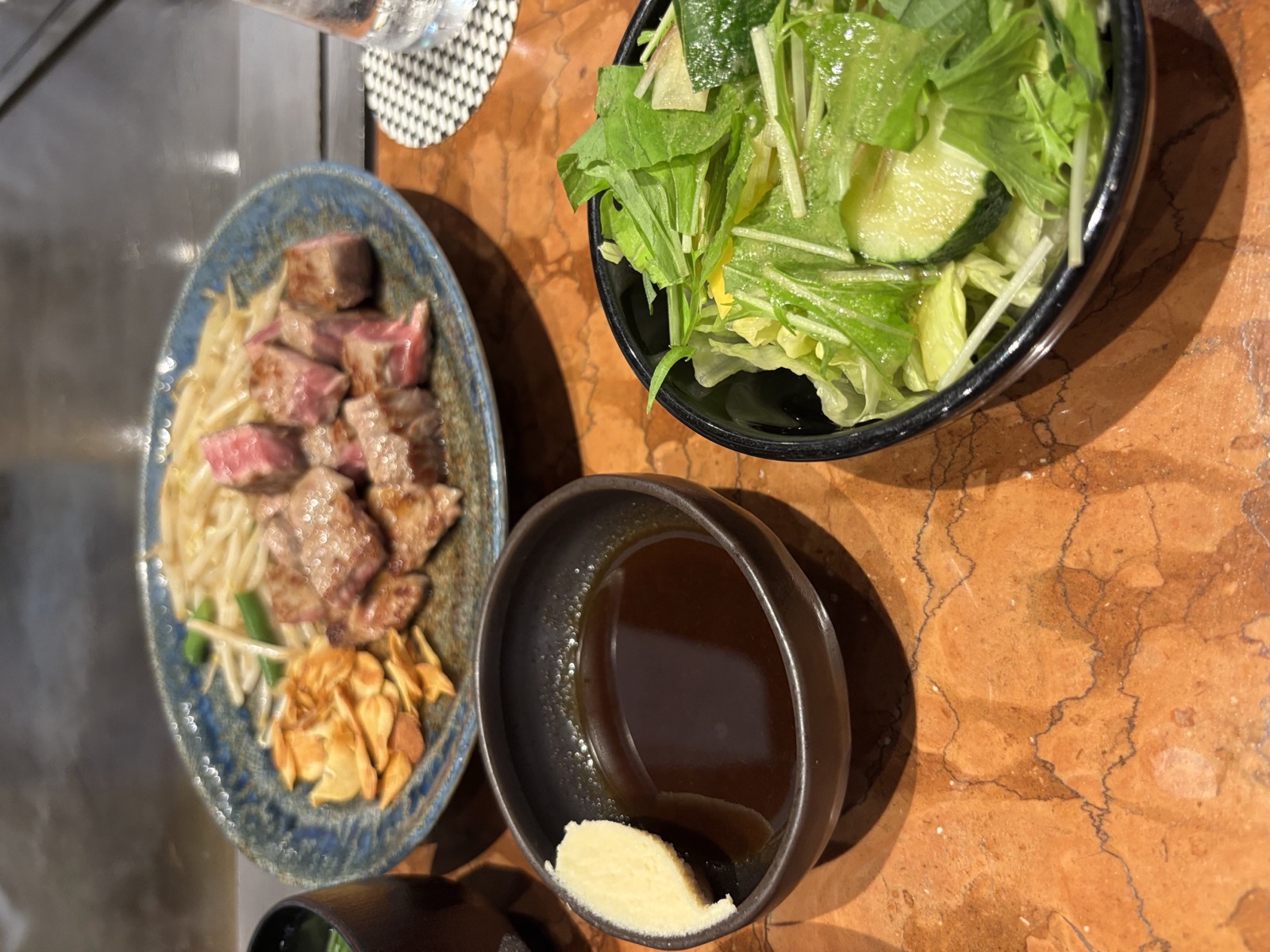 鉄板の前のステーキとサラダ